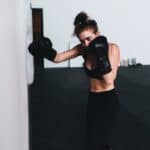 woman in black sports bra and black leggings wearing black boxing gloves